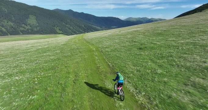Aerial footage of woman riding mountain bike on beautiful forest mountain trail