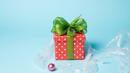 Obraz premium Small red and green wrapped present with white polka dots on top. Includes ribbon and bow.