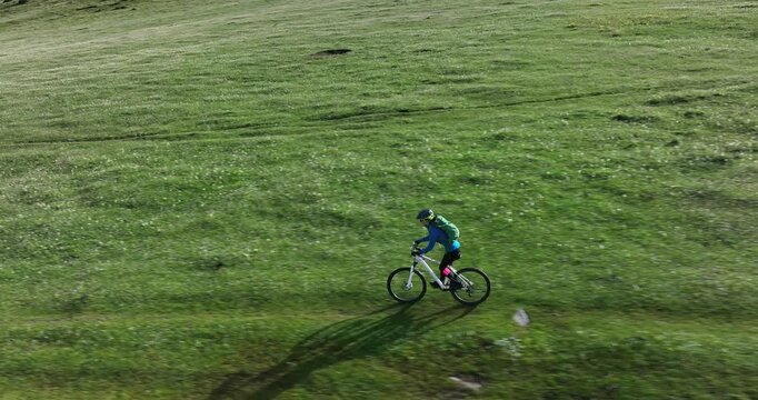 Aerial footage of woman riding mountain bike on beautiful forest mountain trail