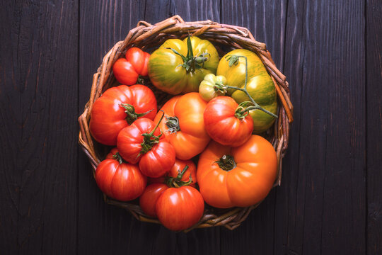 Compact basket filled with cherry and heirloom tomatoes. Vibrant farm produce, healthy food background