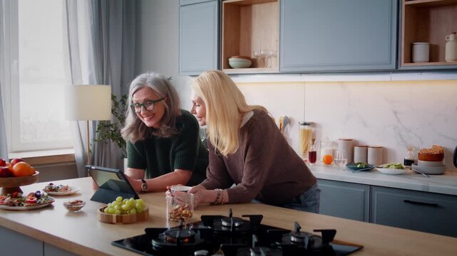 Senior women visit internet store via digital tablet in kitchen