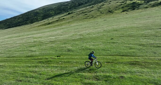 Aerial footage of woman riding mountain bike on beautiful forest mountain trail