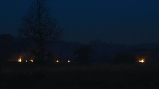 Flames and smoke rising from an unregulated oil field in rural Myanmar after sunset