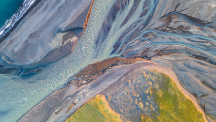 Aerial view of braided river delta meeting the ocean © Nils