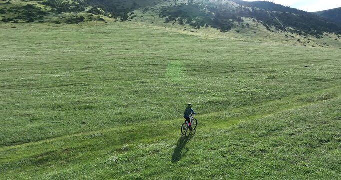 Aerial footage of woman riding mountain bike on beautiful forest mountain trail