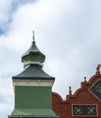 Ornate Green Turret and Red Brick Architecture Under Cloudy Sky © wenjie