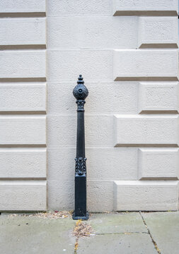 Antique black cast iron bollard against stonee wall.
