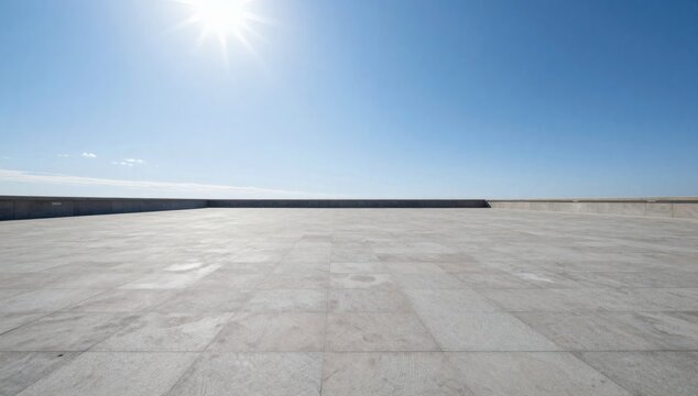 Empty rooftop terrace with bright sunlight and expansive blue sky above