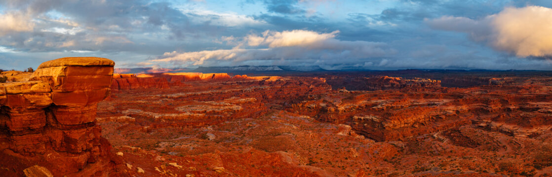 A winter storm passes by at sunset allowing accent light to illuminate the canyon rim near White Crack in Canyonlands National Park, Utah.