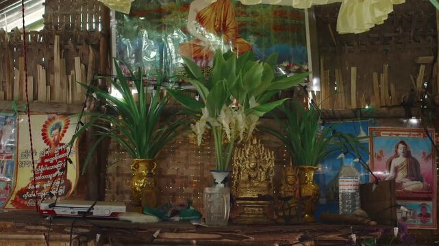 Domestic buddhist altar inside a bamboo hut at an unregulated oil field in Myanmar