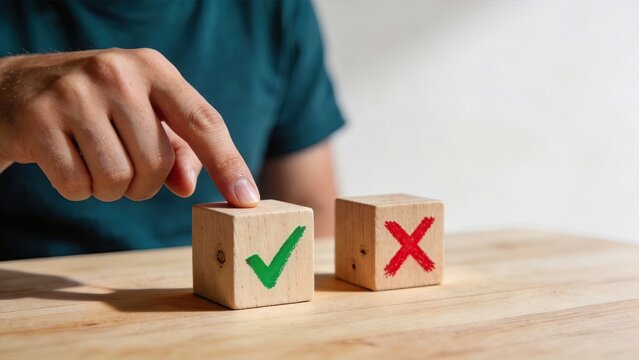 Man hand selecting wooden cube with green checkmark over red cross making decision choosing right option business concept success approval voting selection process positive choice