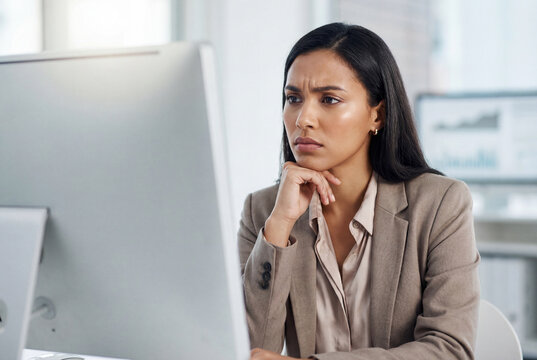 Worried businesswoman looking at a computer monitor