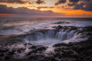 Fototapeta premium El Bufadero geological vent in La Garita at sunrise, Gran Canaria island, Spain. Waves crashing at natural underwater arch. Natural landmark. March 2026, long exposure picture