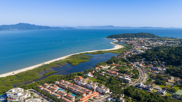 Ponta das Canas beach with sheltered lagoon, lush vegetation and blue sea in Florianopolis.
