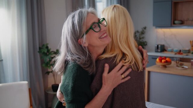 Senior women warmly share joyful reunion hug at home together