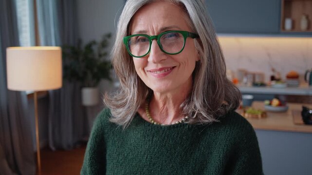 Grey-haired woman smiles with calm confidence in home portrait