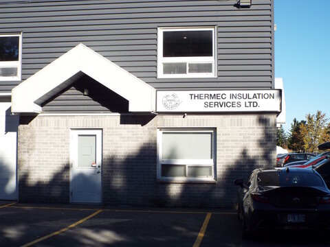 Nepean, Ontario, Canada &ndash; July 27, 2025: The "Thermec Insulation Services Ltd." storefront features a gray brick and siding exterior, a white gabled entryway, and prominent signage at 81 Auriga Drive.