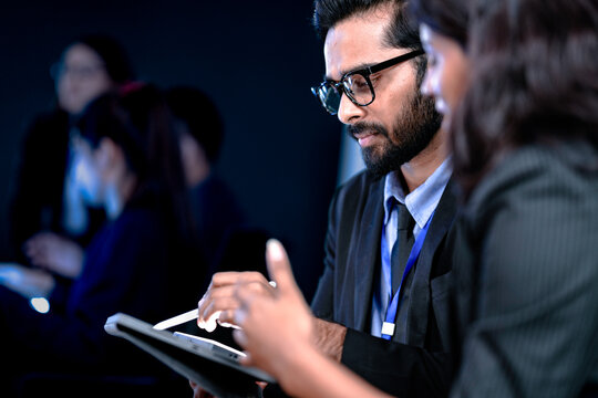 Future AI strategy talk. Male visionary leader explains ethical AI implementation or market disruption plan to female strategist surrounded by futuristic data screens.