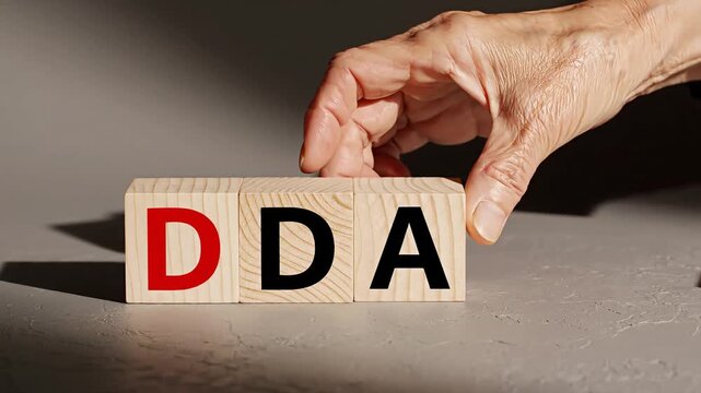 Hand placing wooden blocks with letters.
