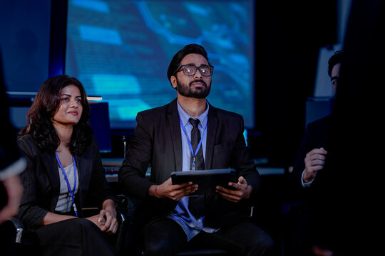 Risk management experts in a strategy meeting discuss AI-powered fraud prevention. This diverse team develops plans to protect customer data and stop financial scammers in fintech.