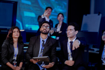 Obraz premium A multi-ethnic leadership team discusses digital transformation. An Indian manager presents a new AI-driven strategy for sustainable ESG goals and future market growth to his diverse team.
