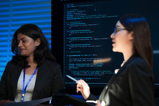 A female tech leader, an Asian woman, presents a new digital transformation strategy using a tablet. Her diverse team discusses sustainable AI solutions for future growth.