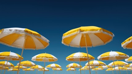 Obraz premium 青空に映える黄色と白のビーチパラソル群。夏のリゾートや海辺の風景素材