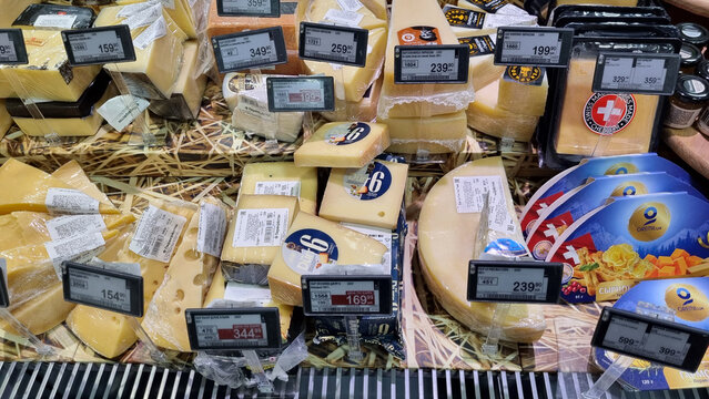 Assortment of cheese in supermarket display with price tags