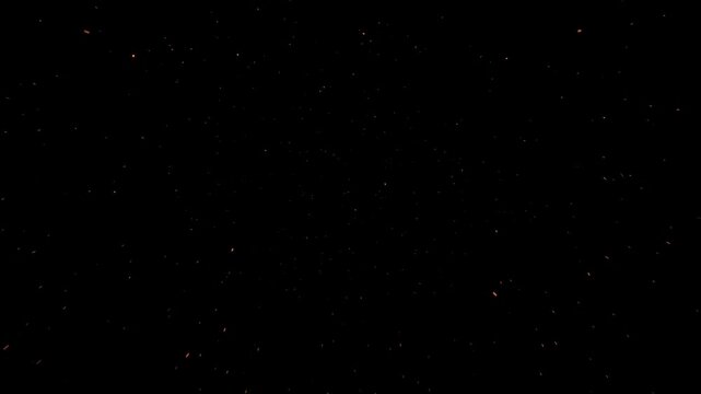 Glowing fire sparks and burning embers flying on black background