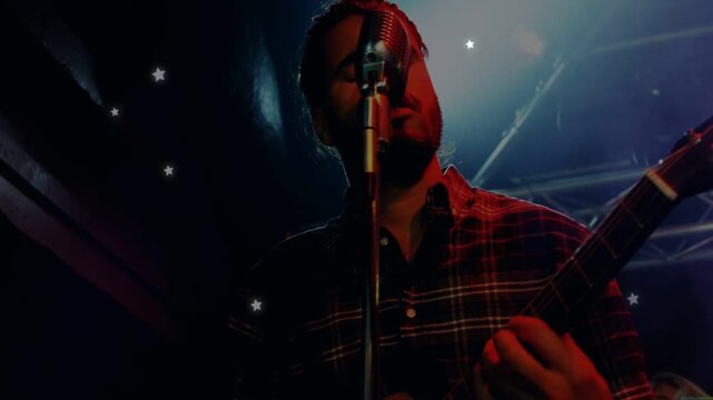 Vertical video: Music lead singer playing guitar singing at mic causing stars as cam pulling back