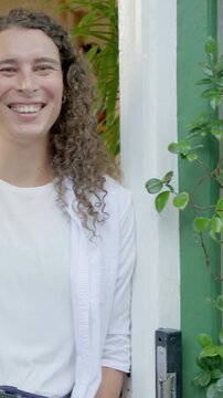 Vertical video: Holding nonbinary adult shifting pot, smiling while camera rolling in entryway