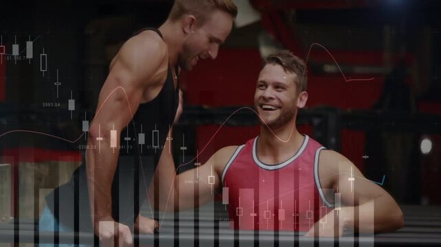 Vertical video: Left man grabbing bar, holding L-sit, partner bracing knees for core finance charts