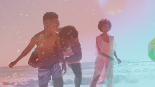 Vertical video: Beach family boy tossing ball as man tickling girl picking flare over family fun