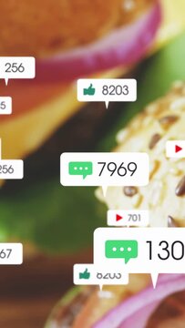 Vertical video: Cam panning, burger showing layers while chat like play bubbles updating engagement