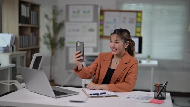 Young Woman Engaged in Video Call While Working in Modern Office