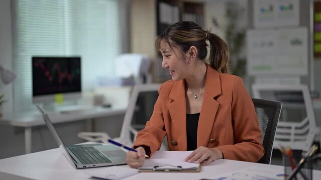 Young Businesswoman Writing Notes at Modern Office Desk