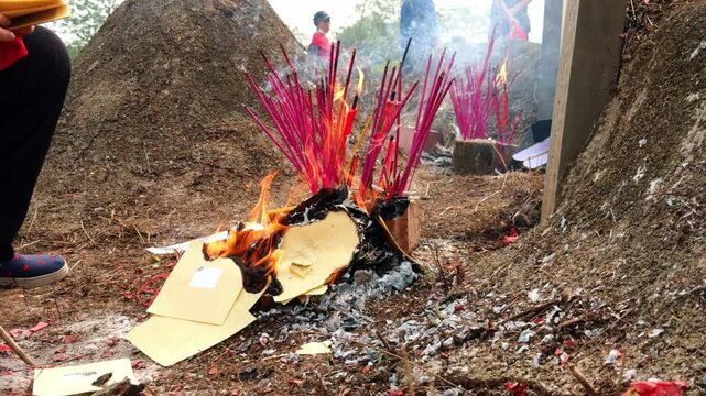 Chinese Qingming Festival activities involving ancestor worship and burning of joss paper.
