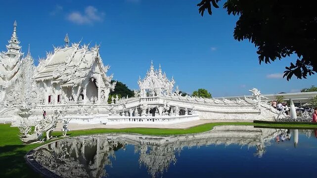 Wat Rong Khun White Temple in Chiang Rai Thailand with Reflection Pond and Blue Sky
