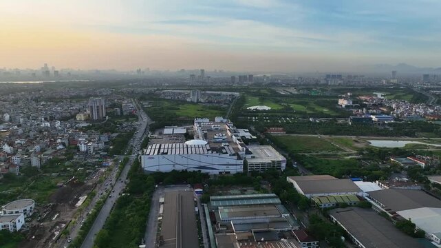 Aerial morning view of an industrial cluster in Long Bien district, Hanoi, showing factory buildings, roads, nearby housing, and expanding suburban landscape.