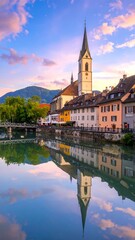 Obraz premium A serene town by a calm river with a church tower