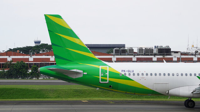 Close up of Citilink aircraft tail fin with green stripe livery design on the tarmac on April 14, 2026 in Soekarno-Hatta Interational Airport, Jakarta, Indonesia.