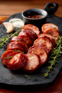lingui&ccedil;a calabresa fatiada sobre uma t&aacute;boa de corte