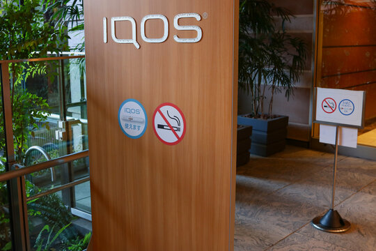 TOKYO, JAPAN - October 3, 2021: Signs at the entrance to a smoking area in a Tokyo shopping center for smokefree devices with a sign indicating that smoking regular cigarettes is not allowed.