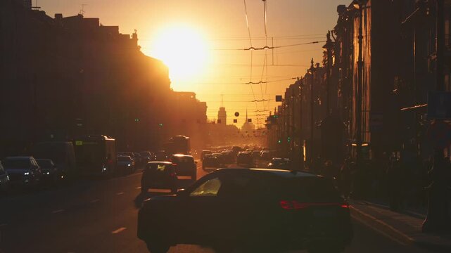 Saint-Petersburg, Russia - April 10 2026, 4k, panoramic view of Nevsky Prospect, cars on road, people walking on sidewalk, at sunset with bright sun, everything in orange light, St Petersburg, Russia