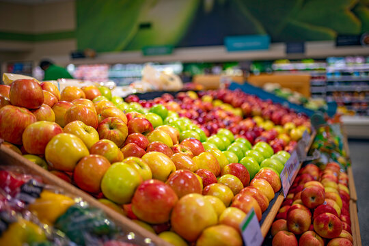Fresh apples display in supermarket produce section with shallow depth of field