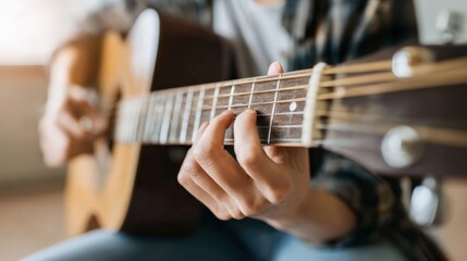 Obraz premium Close-up of person playing acoustic guitar with fingers on strings in bright indoor setting