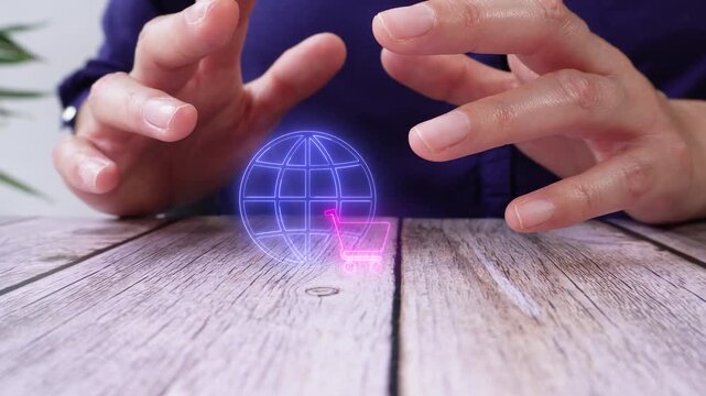 Global online shopping. Close-up of a pair of hands on a table, protecting a virtual globe icon and a shopping cart.