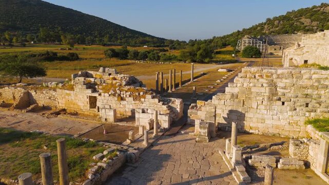 Gelemis, Turkey. Aerial flight from Colonnaded Street over city wall to panorama of Patara ancient city with theatre, parliament, beach and lighthouse. Aerial View