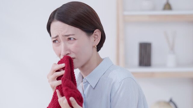 衣替えで出したセーターの臭いを嗅ぐ女性