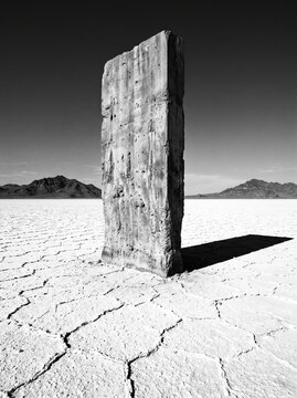 Weathered Concrete Monolith Casting Shadow on White Salt Desert